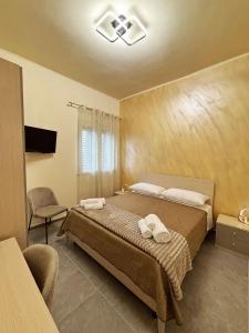 a bedroom with a bed with two towels on it at Villa Silla - Casa Vacanze in Delia