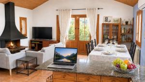 a living room with a table with a laptop on a counter at El Cajigar Ordesa Aínsa in Laspuña