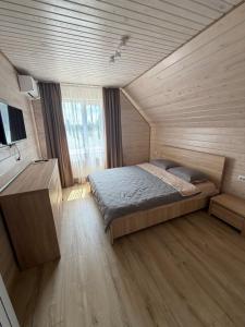 a bedroom with a bed in a room with wooden walls at Садиба Меланія in Svityazʼ
