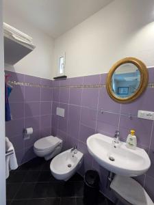 a bathroom with a toilet and a sink and a mirror at B&B Al Bricco in Albisola Superiore