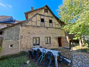 an old building with chairs and a table in front of it at Braui Pub and Restaurant in Waldenburg