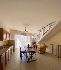 a kitchen and living room with a table and a couch at SteLuRe in Aradeo