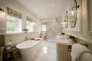 a large bathroom with a tub and a shower at Glenapp Castle in Ballantrae +79 photos