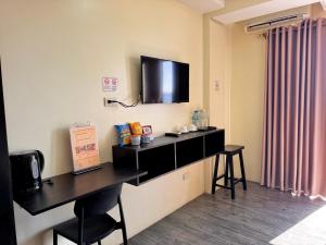 a room with a desk with a tv on the wall at Navarro Hotel in Caticlan