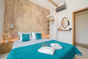 a bedroom with a blue bed with towels on it at Eden's Garden Villa in Ulcinj