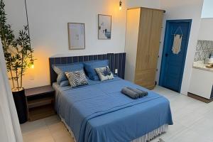 a bedroom with a bed with blue sheets and a blue door at Modern and fully equipped studios in Bosque, downtown area in Rio Branco