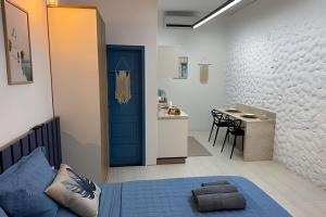 a bedroom with a blue door and a kitchen with a table at Modern and fully equipped studios in Bosque, downtown area in Rio Branco
