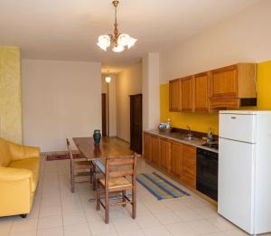 a kitchen with a table and a white refrigerator at SteLuRe in Aradeo