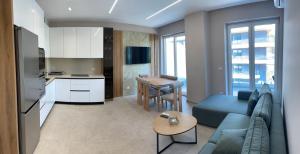 a living room with a blue couch and a kitchen at DreamStay Lezha Apartments - Ilyonis Residence in Lezhë
