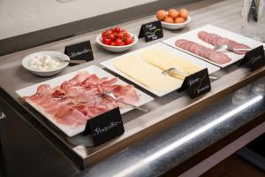 ein Buffet mit Fleisch, Käse und anderen Speisen in der Unterkunft Hotel Villa Bonelli in Fiesole