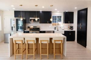 a kitchen with black cabinets and a large white table at Modern Tahoe Retreat in South Lake Tahoe