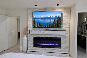 a living room with a fireplace with a tv above it at Modern Tahoe Retreat in South Lake Tahoe