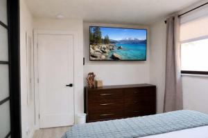 a bedroom with a bed and a tv on the wall at Modern Tahoe Retreat in South Lake Tahoe