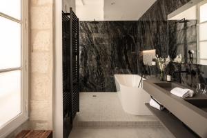 a bathroom with a black and white wall at Hotel des Quinconces Bordeaux Centre in Bordeaux +26 photos