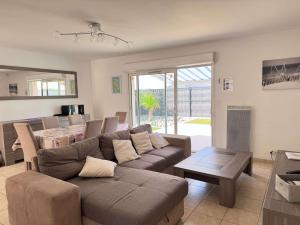 a living room with a couch and a table at Avec piscine à Dolus in Dolus-d'Oléron