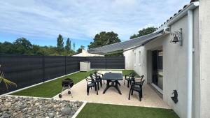 a patio with a table and chairs and a fence at Avec piscine à Dolus in Dolus-d'Oléron