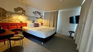 a hotel room with a bed and a table and a desk at Hôtel des quatre saisons in Guérande