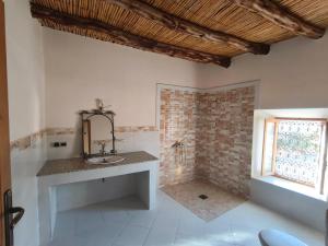 a bathroom with a sink in a room with a window at Riad tinghir in Tinerhir