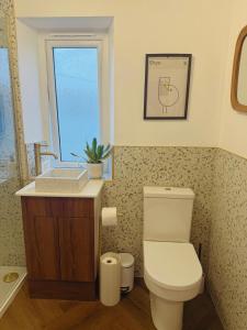 a bathroom with a toilet and a sink and a window at This must be the place - Skye, Carbost in Carbost +37 photos