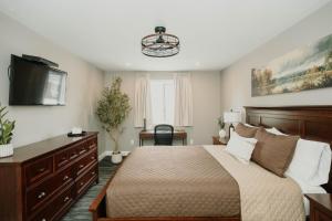 a bedroom with a large bed and a television at Manitoulin Inn in Mindemoya