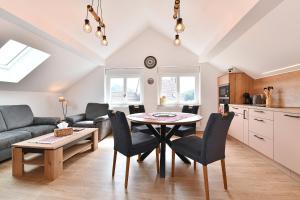 a kitchen and living room with a table and chairs at Printemps et Eté en Alsace in Stosswihr