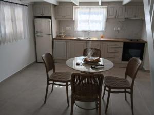 a kitchen with a table and chairs and a refrigerator at Liodentro House in Karpathos