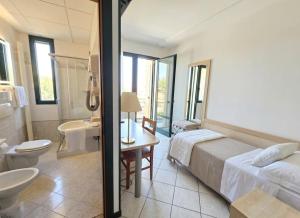 ein Hotelzimmer mit Bett und Badezimmer in der Unterkunft GRAN DELTA River & Nature Hotel in Rosolina + 39 Fotos