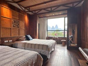a hotel room with two beds and a window at Yangshuo Shui Mo Ju courtyard-Yangshuo Raiway St'ation free pick up for two nights in Yangshuo +92 photos