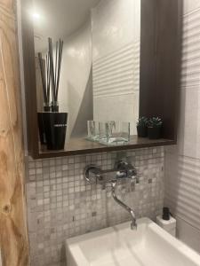 a bathroom with a sink and a mirror and plants at L écrin du Luberon in Cadenet
