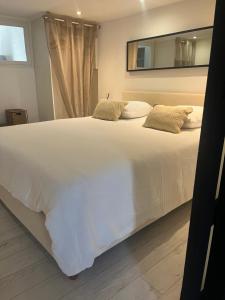 a large white bed in a room with a window at L écrin du Luberon in Cadenet
