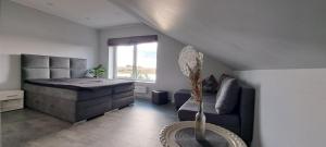 a bedroom with a bed and a couch and a window at Villa reed in Dasiūnai