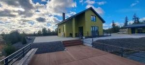 a small yellow house on a wooden deck at Villa reed in Dasiūnai