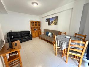 a living room with a table and a couch at Casa Caravela B in Armação de Pêra