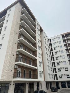 a large apartment building with cars parked in front of it at Apartman NOVA in Kragujevac