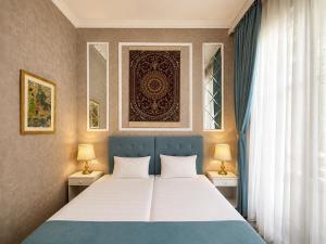 a bedroom with a bed and two lamps and a window at La Casa Boutique Nizami in Baku