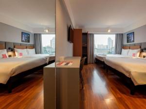 a hotel room with three beds and a window at ibis Guarulhos Aeroporto in Guarulhos +120 photos