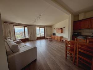 a living room with a white couch and a kitchen at Hostal Bertran in Salás de Pallás