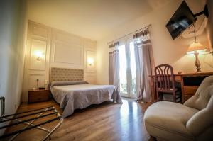 a bedroom with a bed and a desk and a couch at Castellu Rossu in Lucciana