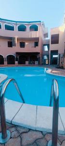 a swimming pool in front of a building at Gina&Gian Guest House in Olbia