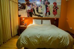 a bedroom with a bed and a painting on the wall at Hospedaje wisny in in Puno +4 photos