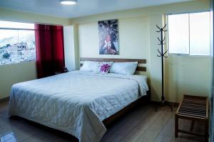 a bedroom with a large bed in a room with windows at Hospedaje wisny in in Puno