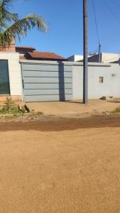 a building with a garage door in front of a street at Lar doce lar in Barra do Garças