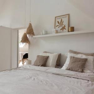 a white bedroom with a large white bed with pillows at Le Grenier in Trois-Ponts