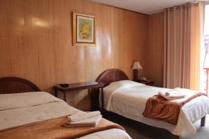 a hotel room with two beds and a window at Kaaro Hotel Suite in Puno