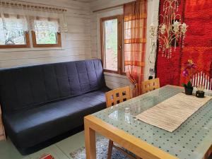 a living room with a couch and a table at Metsämökki in Lohja +34 photos