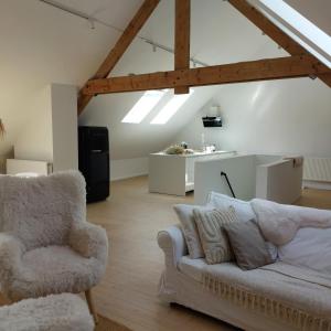 a living room with a couch and a chair at Le Grenier in Trois-Ponts