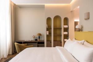 a bedroom with a white bed and a desk at Hotel des Quinconces Bordeaux Centre in Bordeaux