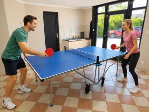 a man and a woman playing a game of ping pong at Bauernhaus 3 -Vaest- in Fehmarn