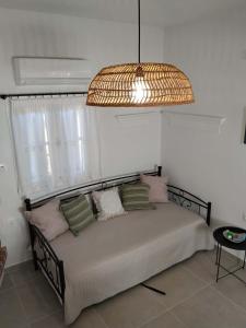 a bedroom with a bed with a chandelier at Liodentro House in Karpathos