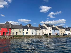 a row of houses next to a body of water at Bolishka Whispers, Spacious Bright Studio accom in Galway